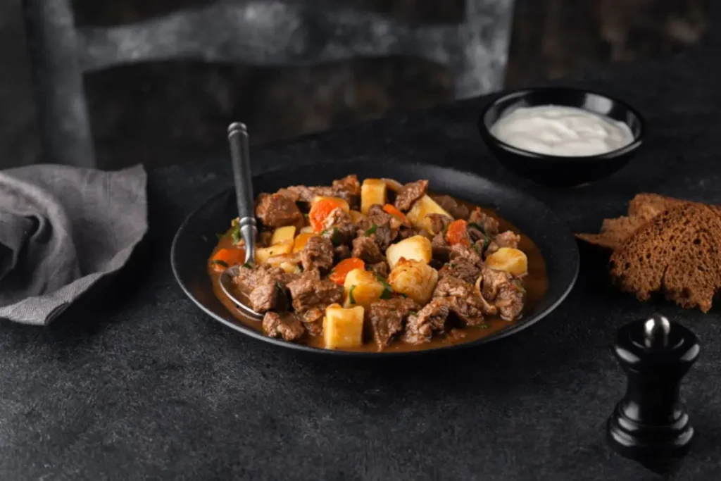 Slow-cooked deer pot roast with vegetables in a serving dish, garnished with fresh herbs.