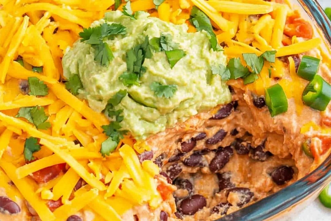 7 Layer Dip: Packed with Refried Beans, Tangy Guacamole, Spiced Sour Cream, Zesty Salsa, and Topped with Cheese